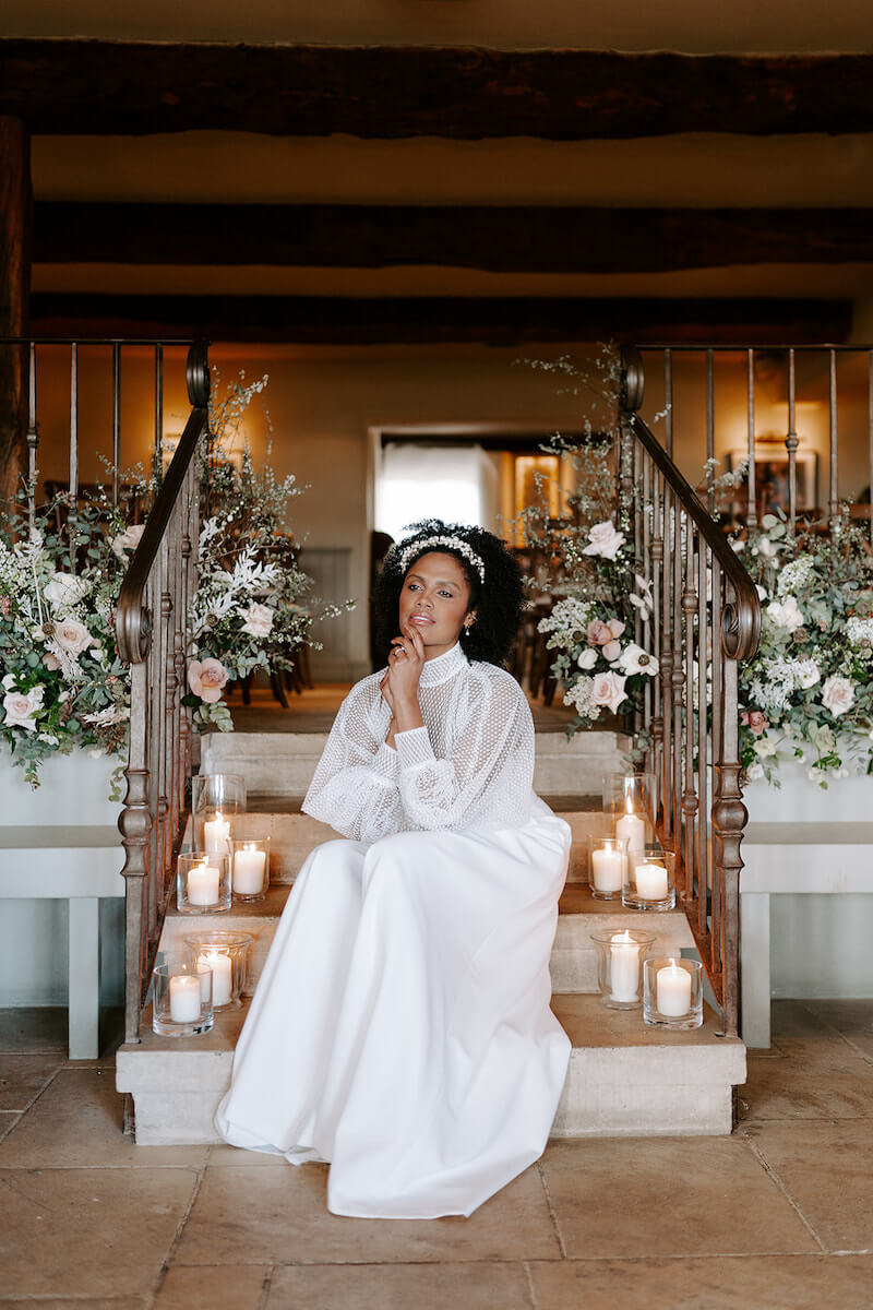 a bride sitting on candlelit steps in The Feathered Nest Inn