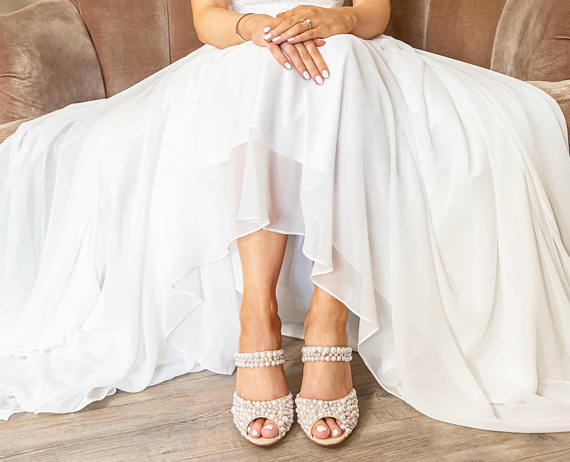 bride seated showing ivory skirt and pearl shoes 