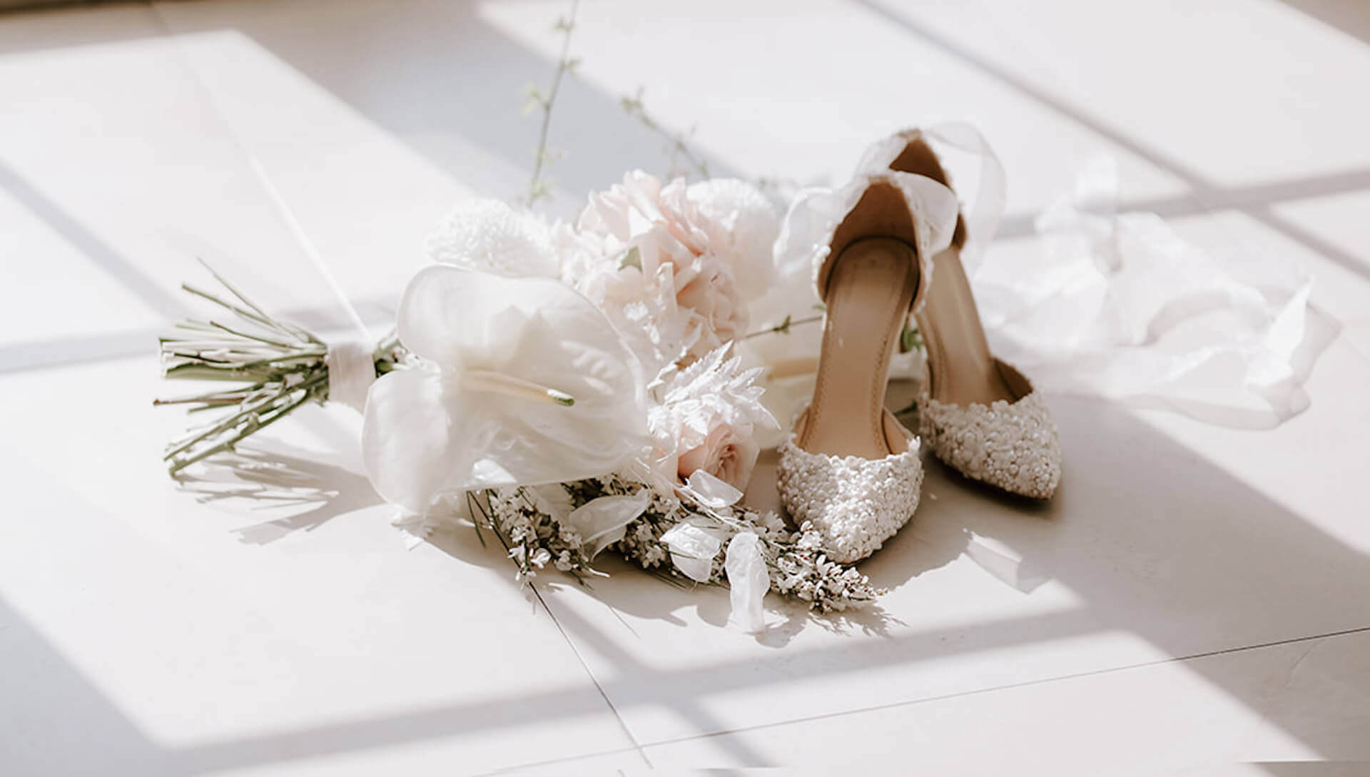 wedding shoes and bouquet in a light window
